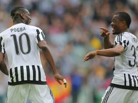 Juventus midfielder Paul Pogba (L) celebrates after scoring with teammate and fellow Frenchman Patrice Evra during the Italian Serie A match against Palermo at the Juventus stadium in Turin on April 17, 2016