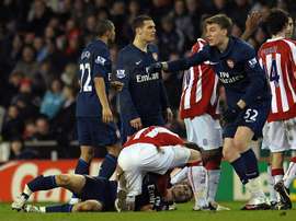 Stoke city's Glenn Whelan attends to Arsenal's Aaron Ramsey in 2010. AFP