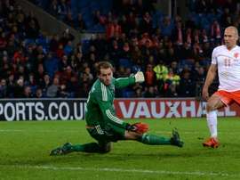 Netherlands midfielder Arjen Robben (R) slots the ball past Waless goalkeeper Owain Fon Williams (L) to score Netherlands third goal during the international friendly football match in south Wales on November 13, 2015