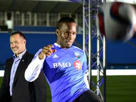 Ivorian striker Didier Drogba kicks the ball in front of Montreal Impact president Joey Saputo after a press conference on July 29, 2015 in Montreal
