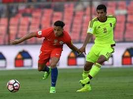 Chiles Alexis Sanchez (L) fights for the ball with Venezuelas Renzo Zambrano