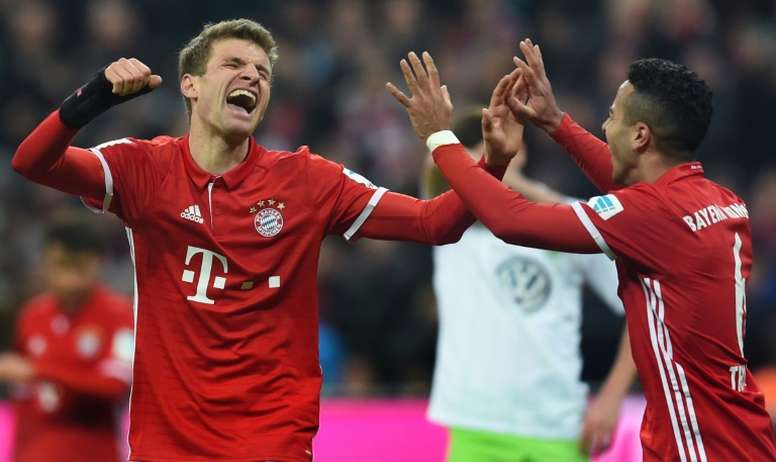 Bayern Munichs Thomas Mueller (L) and Thiago Alcantara (R) celebrate after the third goal for Munich against Wolfsburg on December 10, 2016