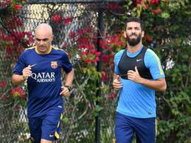 Barcelonas new player Arda Turan (R) runs with a trainer during a light training session at the StarHub Stadium in Carson, California, on July 20, 2015