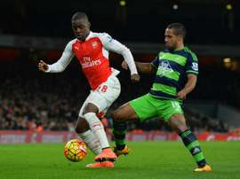 Campbell (L) is put under pressure by Swansea's Wayne Routledge. AFP