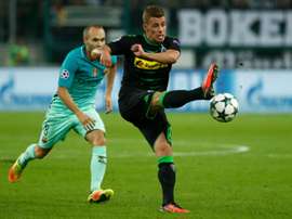 Thorgan Hazard (R) kicks the ball in front of Barcelona midfielder Andres Iniesta. AFP
