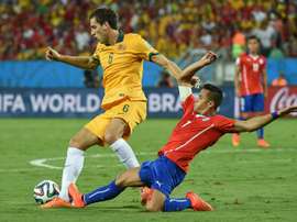Australias Matthew Spiranovic (L) fights for the ball with Chiles Alexis Sanchez during their 2014 FIFA World Cup group match