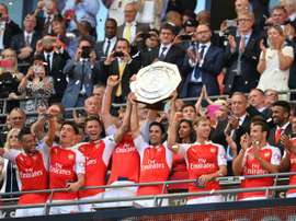 Arsenals midfielder Mikel Arteta (C) lifts the trophy as Arsenal players celebrate after beating Chelsea in the FA Community Shield football match at Wembley Stadium in north London on August 2, 2015