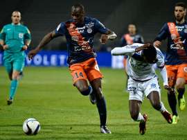Montpelliers French midfielder Bryan Dabo (L) vies for the ball with Lyons French forward Maxwel Cornet (R) during the French L1 football match at the Gerland Stadium in Lyon, central-eastern France, on November 27, 2015