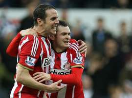 Sunderland captain John OShea (L) celebrates with teammate Adam Johnson at the end of the Premier League match against Newcastle United at St James Park on December 21, 2014
