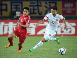 Chinas Rao Weihui (R) challenges North Koreas Ro Hak Su during the mens East Asian Cup football match in Wuhan on August 5, 2015