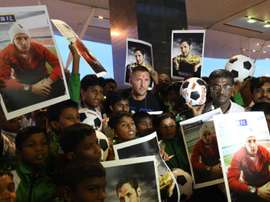 Italian footballer Marco Materazzi (top C) poses with football fans who had gathered at the Kempegowda International Airport to welcome him on his arrival in Bangalore on September 20, 2014