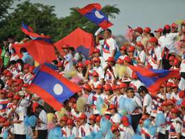 Laos supporters wave national flags during a football match in Vientiane