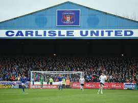 Fans line the terraces behind the goal during the English FA Cup fourth round football match between Carlisle United and Everton at Brunton Park, in Carlisle, north west England, on January 31, 2016