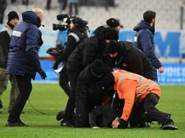 A club at war: Marseille security staff wretsled pitch invaders to the ground at the final whistle