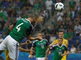 Northern Ireland defender Gareth McAuley (L) scores the opening goal against Ukraine. BeSoccer