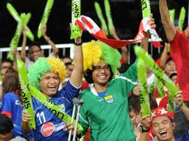 Supporters for the Lions XII team cheer during a football match in Singapore on January 10, 2012