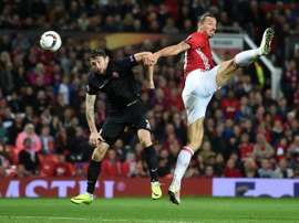 Manchester Uniteds striker Zlatan Ibrahimovic (R) vies in the air with Zoryas Belarusian defender Mikhail Sivakov as he heads the ball towards goal during the UEFA Europa League group A football match between Manchester United and Zorya Luhansk