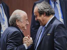 FIFA President Sepp Blatter (L) shaking hands with UEFA President Michel Platini in Zurich on May 29, 2015