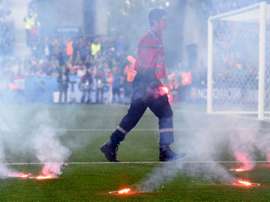 A fire fighter extinguish flares lobed onto the pitch during the Euro 2016 group D football match between Czech Republic and Croatia at the Geoffroy-Guichard stadium in Saint-Etienne on June 17, 2016