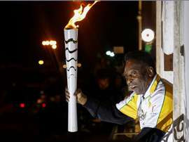 Former football player Pele holds the Olympic flame at the Pele Museum in Santos, Sao Paulo State, Brazil, on July 22, 2016