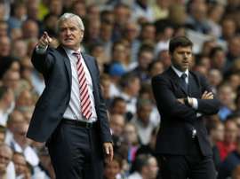 Tottenham Hotspurs Argentinian Head Coach Mauricio Pochettino (R) and Stoke Citys Welsh manager Mark Hughes (L) watch from the touchline during the English Premier League football match at White Hart Lane in north London on August 15, 2015