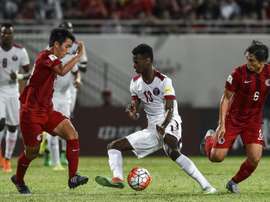Qatars Mohammed Muntari (C) dribbles the ball past Hong Kongs Huang Yang (R) during their 2018 World Cup football qualifying match in Hong Kong on September 8, 2015
