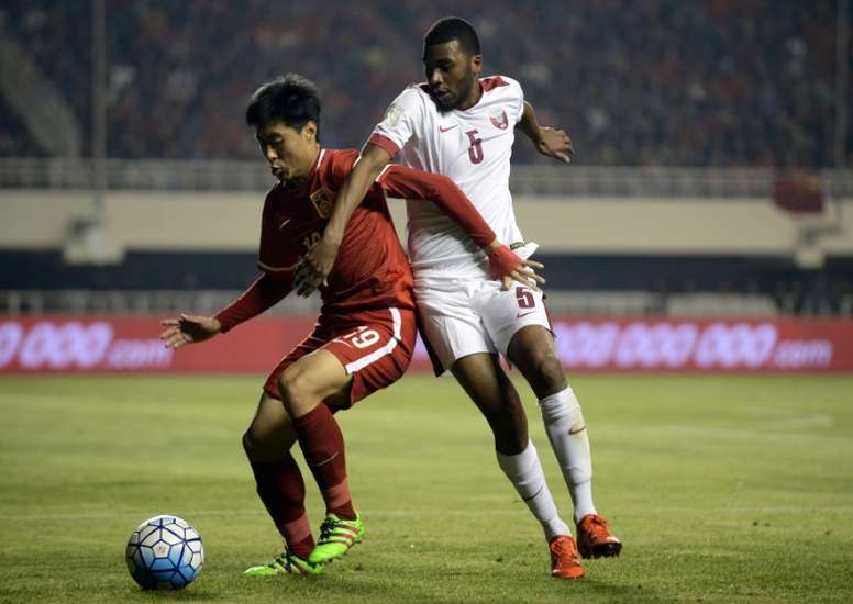 Jiang Ning (left) of China competes for the ball with Abdelaziz Hatim of Qatar during their 2018 World Cup football qualifying match in Xian, northwest Chinas Shanxi province on March 29, 2016