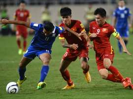 Thailands Mongkol (left) holds off two Vietnamese players during a World Cup 2018 qualifier at My Dinh stadium in Hanoi, on October 13, 2015. Thailand defeated Vietnam 3-0