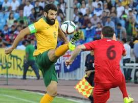 Australias Mile Jedinak (L) and Kyrgyzstans Viktor Maier during the FIFA World Cup 2018 Group B qualifying match in Bishkek on June 16, 2015