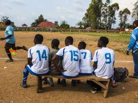 Local football players follow a match from the bench in Beni, DR Congo. AFP