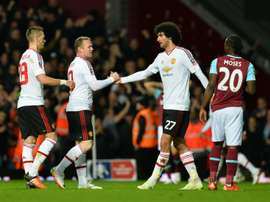 Manchester Uniteds striker Wayne Rooney (2ndL) congratulates midfielder Marouane Fellaini (C) after winning the FA cup quarter final replay on April 13, 2016