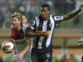 Milton Casco (left), of Argentinas Newells Old Boys, vies for the ball with Jo, of Brazils Atletico Mineiro, during their 2013 Copa Libertadores second leg semifinal football match at Arena Independencia Stadium in Belo Horizonte, on July 10, 2013