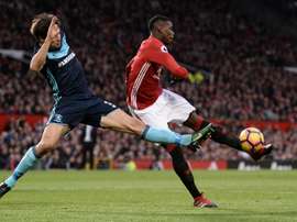 Manchester Uniteds midfielder Paul Pogba (R) attemps to shoot past Middlesbroughs defender George Friend during the English Premier League football match at Old Trafford in Manchester, north west England, on December 31, 2016