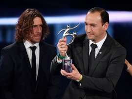 Colombian executive and chairman of Atletico Nacional Juan Carlos de la Cuesta (R) holds The 2016 FIFA Fair Play Award next to former Spanish football player Carles Puyol during The Best FIFA Football Awards ceremony, on January 9, 2017 in Zurich