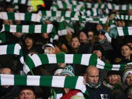 Celtic fans hold up team scarves in Glasgow. AFP
