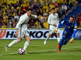 Real Madrids forward Cristiano Ronaldo (L) vies with Las Palmas goalkeeper Raul Lizoain Cruz at the Gran Canaria stadium in Las Palmas de Gran Canaria on September 24, 2016.