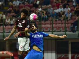 AC Milans forward from Brazil Luiz Adriano (L) jumps for the ball during the Italian Serie A football match between AC Milan and Empoli at San Siro Stadium in Milan on August 29, 2015