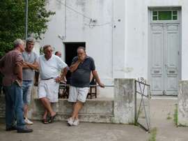 Friends console Emiliano Sala's father Horatio (second from right) outside his house. AFP