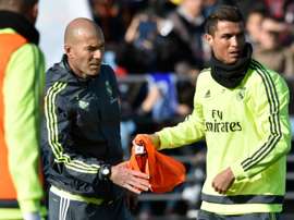 Real Madrid forward Cristiano Ronaldo (R) gives a bib to new French coach Zinedine Zidane during his first training session as coach at the Alfredo di Stefano stadium in Valdebebas, on the outskirts of Madrid, on January 5, 2016