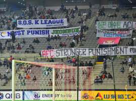 Football fans display banners protesting against Jeonbuk Hyundai Motors bribing of referees. AFP