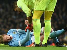 Manchester Citys midfielder Kevin De Bruyne (L) reacts as he talks with Evertons goalkeeper Joel Robles before being stretchered off during an English League Cup semi-final match at the Etihad Stadium in Manchester on January 27, 2016