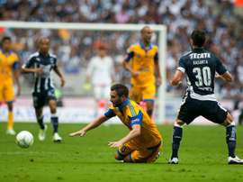 Lattaquant André-Pierre Gignac (à terre) des Tigres face aux joueurs de Monterrey lors du Tournoi de clôture du Championnat du Mexique, le 14 mai 2016 à Monterrey