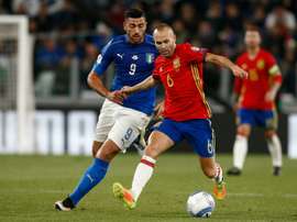 Graziano Pellè à la lutte avec le milieu espagnol Andres Iniesta lors des qualifs. AFP
