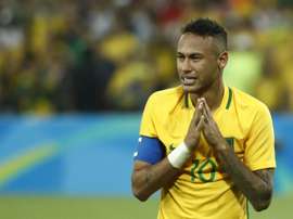Neymar la toma con un aficionado en la celebración del oro. AFP