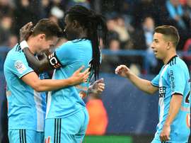 Florian Thauvin félicité par son capitaine Bafé Gomis après un de ses trois buts à Caen. AFP