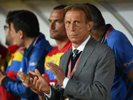 Christoph Daum, ex-sélectionneur de la Roumanie, applaudit lors du match face au Montenegro. AFP