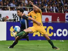 L'attaquant japonais Shinji Okazaki face à l'Australien Brad Smith à Saitama au Japon. AFP