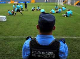 Un membre de la police hondurienne surveille l'entraînement de l'équipe d'Australie. AFP
