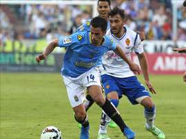 El centrocampista del UD Las Palmas Hernán Santana (i) y el defensa del Real Zaragoza Mario Abrante, durante el partido de ida de la final para el ascenso a Primera División, que disputaron en el estadio de la Romareda. EFE