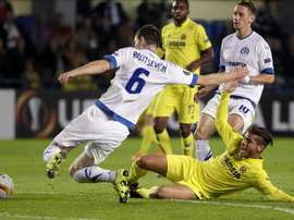 El centrocampista mexicano del Villarreal Jonathan Dos Santos (d) lucha el balón con Sergei Politevich, defensa del Dínamo de Minsk, durante el partido correspondiente a la tercera jornada de la fase de grupos de la Liga Europa que se juega esta noche en el estadio de El Madrigal, en Villarreal. EFE